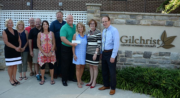 Board presenting a check to Gilchrist